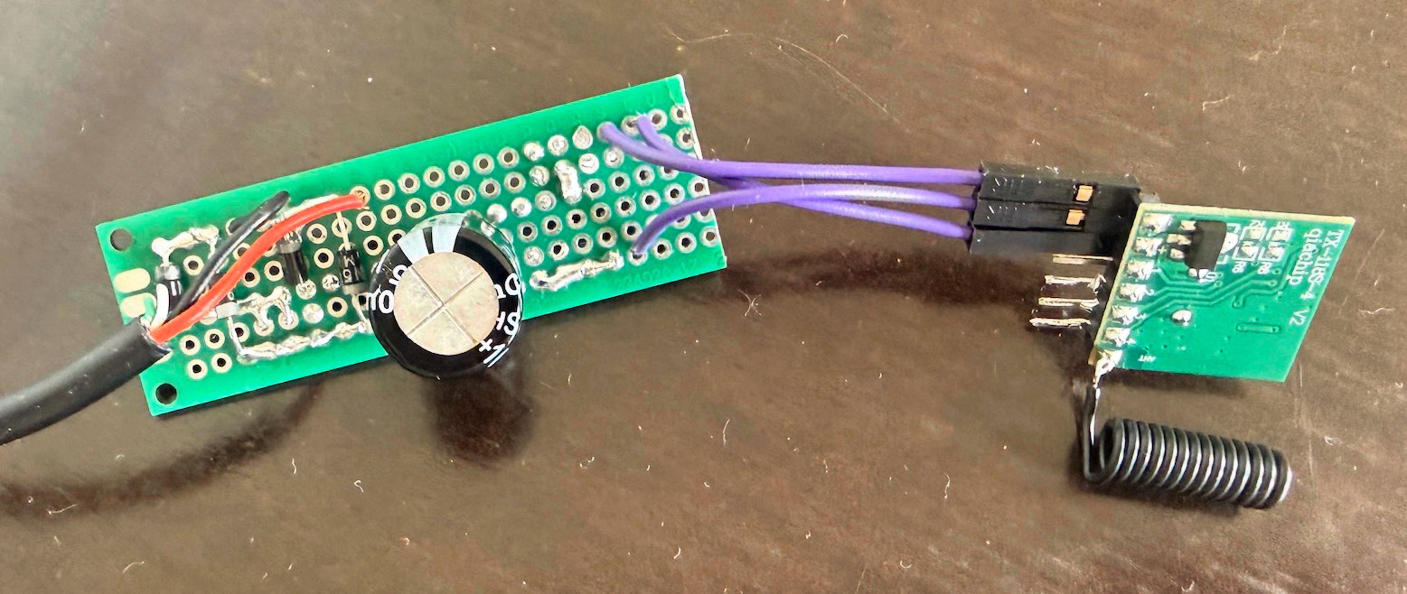 A small perfboard with the bridge rectifier and buffer capacitor soldered on the left, and the TX118SA-4 module on the right with its coiled wire antenna.